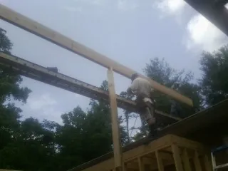 Carpenter setting a ridge beam over a new addition frame — Ice Dam Removal by Roofing Brothers in Gaston